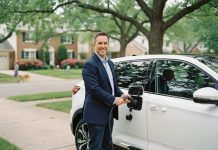 Homme souriant avec voiture électrique moderne dans la rue